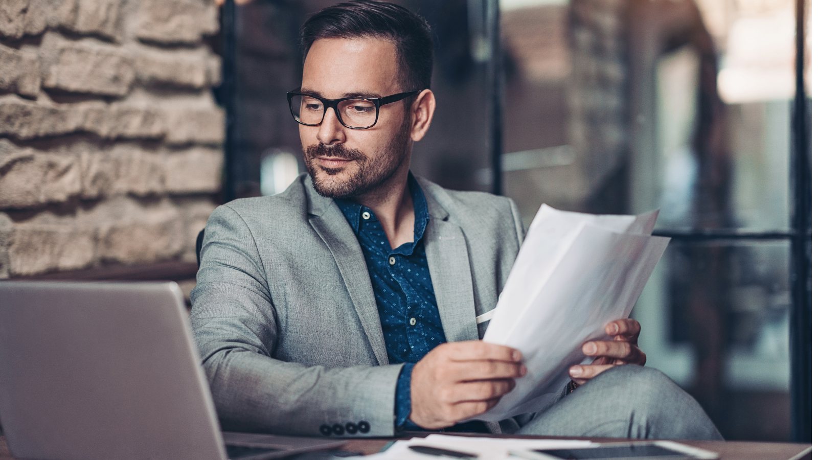 Serious businessman with laptop and documents 