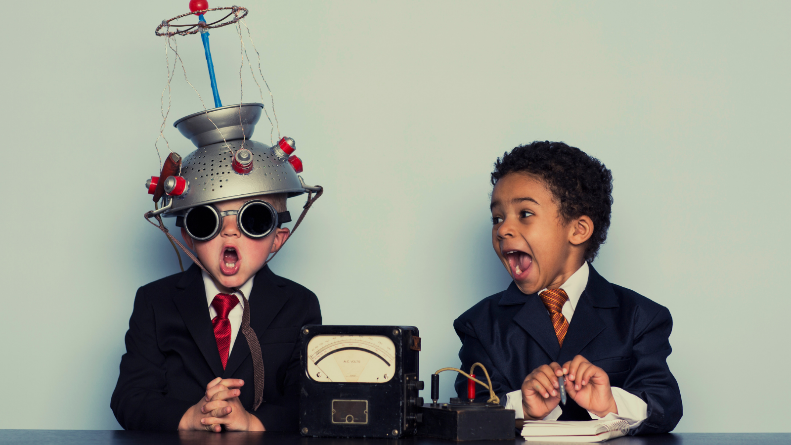 Two young business boys try to think of great ideas with light bulb helmet